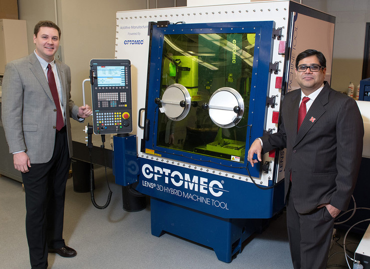 Michael Sealy and Prahalada Rao standing in front of a new hybrid 3D printer.