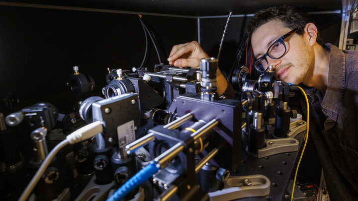 Adam Erickson, a doctoral student in materials engineering, adjusts the nitrogen-vacancy scanning probe in Abdelghani Laraoui's lab.